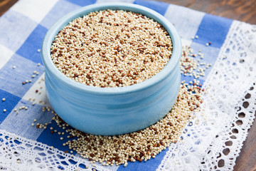 Organic quinoa grains in blue ceramic bowl, Gluten free. Concept Healthy food. Seeds of Chenopodium quinoa