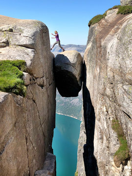 Woman jumps from  Kjeragbolten stone stuck between two rocks