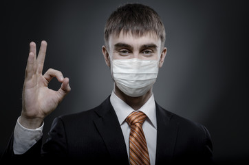 portrait businessman in medical mask to give hand gesture o.k.