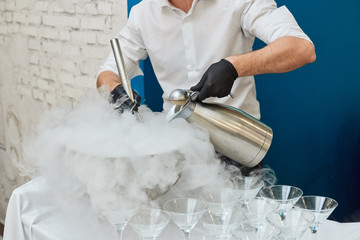 Man making cryogenic ice cream using liquid nitrogen and steam from dry ice.
