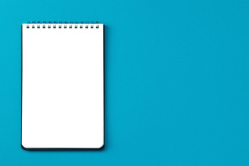 Copy space notepad on a blue background top view.