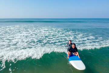 surf instructor and woman learning extreme water sport in Goa