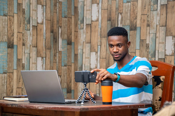 young man making a vlog, interacting with viewers, working from home, doing a live video chat