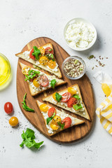 Cherry tomatoes cottage cheese toasts.Top view, copy space.