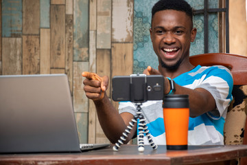 young man making a vlog, interacting with viewers, working from home, doing a live video chat