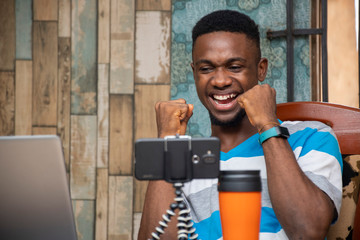 young man making a vlog, interacting with viewers, working from home, doing a live video chat