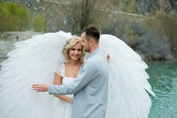 the girl hugs the guy in white angel wings dress