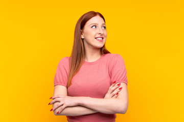 Young redhead woman over isolated yellow background laughing