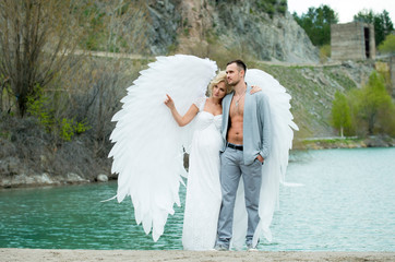 the girl hugs the guy in white angel wings dress