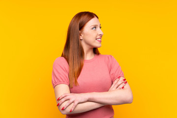 Obraz premium Young redhead woman over isolated yellow background looking to the side