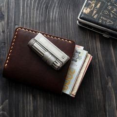 Men accessories. Cigarette lighter and leather wallet on a wooden background