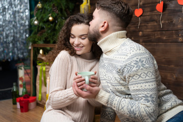 Fototapeta premium Cheerful couple in sweaters celebrating holidays together