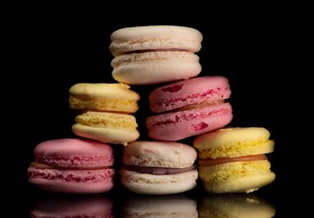 Macarons on a isolated black background.  is a sweet meringue-based confection made with egg white,...