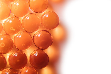 Fish oil capsules. Many round tablets of red-orange color.
