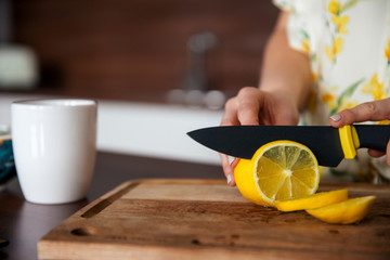 Woman with knife cuts lemon. The concept of eco-friendly products for cooking