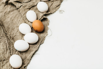 chicken eggs with a feather on a fabric on a white background, environmental friendliness, bright easter