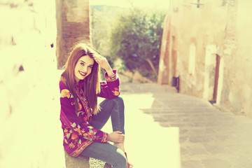 Obraz premium beautiful young girl sitting on the streets of the old town