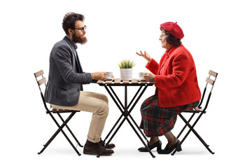 Elderly woman and a bearded younger man talking over a cup of coffee