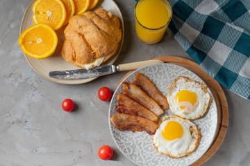 classic English breakfast with oatmeal, egg, toast, jam, bacon and butter balls on a wooden board