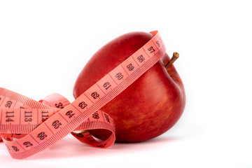 Proper nutrition. Measuring tape  and red apple on a white isolated background. Achieving the goal of losing weight and diet.