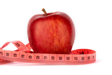 Proper nutrition. Measuring tape  and red apple on a white isolated background. Achieving the goal of losing weight and diet.