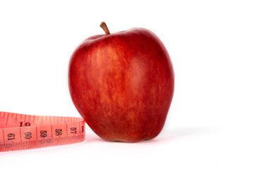 Proper nutrition. Measuring tape  and red apple on a white isolated background. Achieving the goal of losing weight and diet.