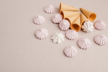 Small crispy waffle ice cream cups with colored marshmallows on a pastel background