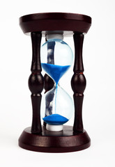 Hourglass wooden clock with blue sand on a white background, isolate