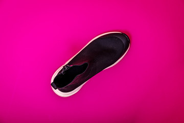 Beautiful fashionable socks sneakers on a pink background. Minimal design of . Stylish black sneakers. Training time concept.