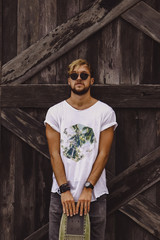 Hipster style guy. young skater man with a skateboard in casual wear