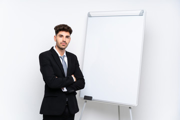 Young businessman giving a presentation on white board with arms crossed while giving a presentation on white board