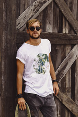 Hipster style guy. young skater man with a skateboard in casual wear