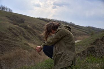 Alone girl on beautiful mountain view feeling free with wind  and sky. Isolated woman on nature background, freedom, post apocalypse