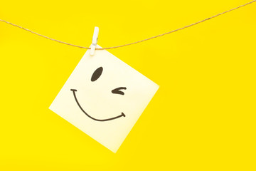 
A painted smiley on a white sheet hangs on a rope. Positive thinking concept. hiding some bad...