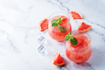 Ruby red grapefruit cocktail with mint leaves in glasses