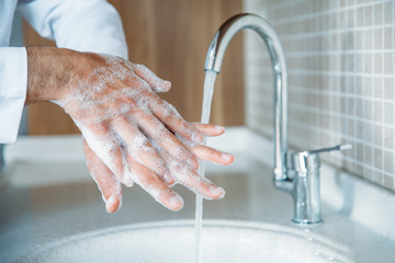 Man washing hands properly with soap to be protected for Coronavirus 2019-nCoV pandemic epidemic infection. Doctor shows how to wash hands properly.