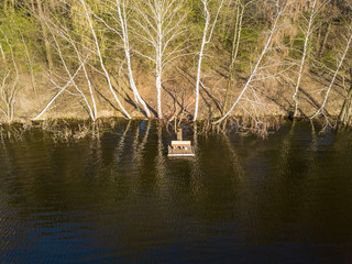 Gangway on a forest lake with a bench on it. Aerial drone view.
