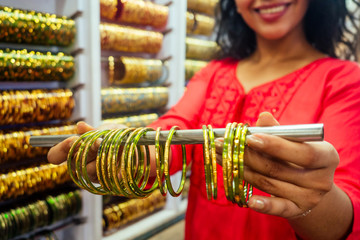young indian woman show traditional ethnic bracelets in her small market in Goa