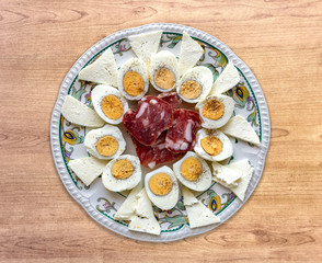 Plate with salted ricotta, salami and boiled eggs