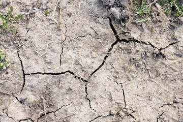 Gray cracked ground. Arid soil, a problem for agriculture. Deserted abandoned area. View from above. Grunge style.