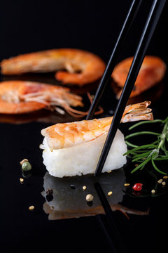 Sushi ebi with shrimp on a  black glass table.
