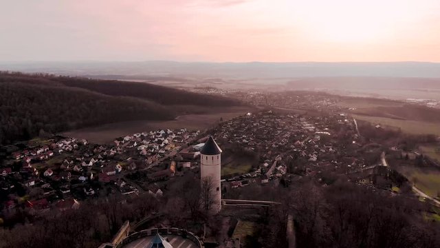 Flying over the two towers left over from an ancient castle in Europe at sunset. The ruins of the castle of Plesse. European village in spring