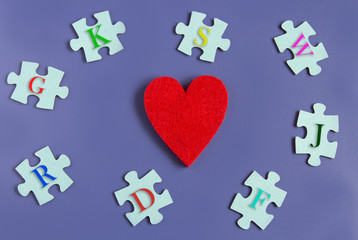 many puzzle pieces with letters and hearts idea of love on a blue background. Copyspace for text