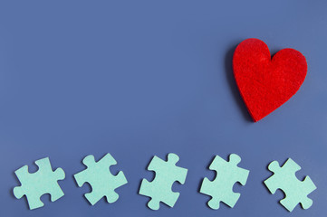 many puzzle pieces and hearts idea of love on a blue background. Copyspace for text