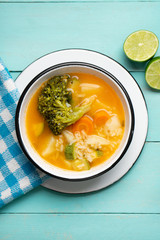 Vegetables soup with rice on turquoise background