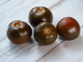 Black tomato kumato on wooden background