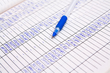 Figures and pen close up fragment of a document with financial statement. Concept balance, bills