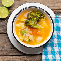Vegetables soup with rice on wooden background