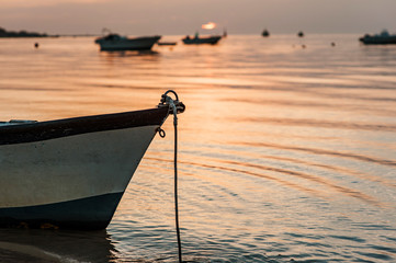 A small boat in a beach in cadiz at sunset