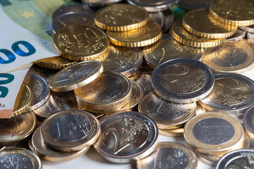 Many Euro coins and euro bills. Banknotes on the left and coins on the right. Shiny Euro Coins in large denomination